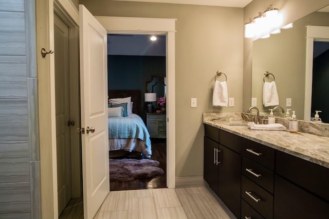 bathroom with vanity, ensuite bathroom, and baseboards