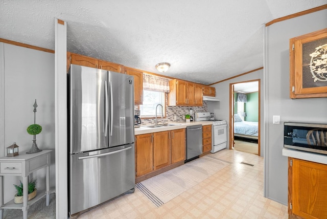 kitchen featuring ornamental molding, a sink, stainless steel appliances, light countertops, and light floors