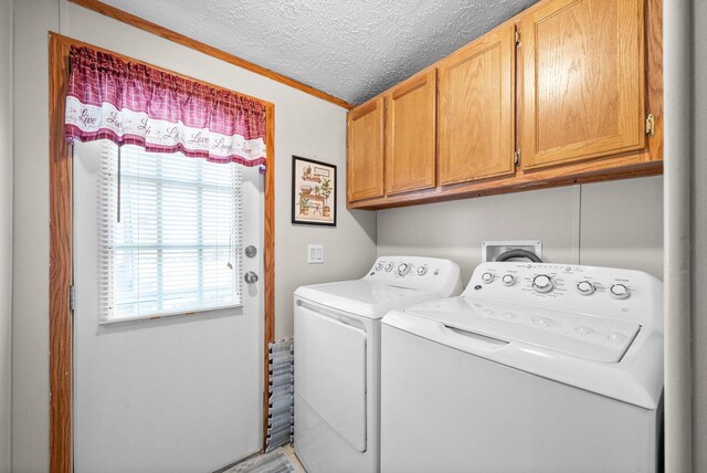 washroom with cabinet space, a textured ceiling, and separate washer and dryer