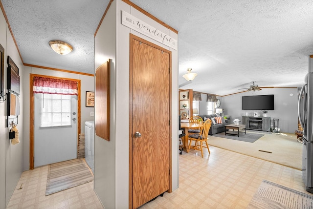 corridor featuring lofted ceiling, light floors, crown molding, and a textured ceiling