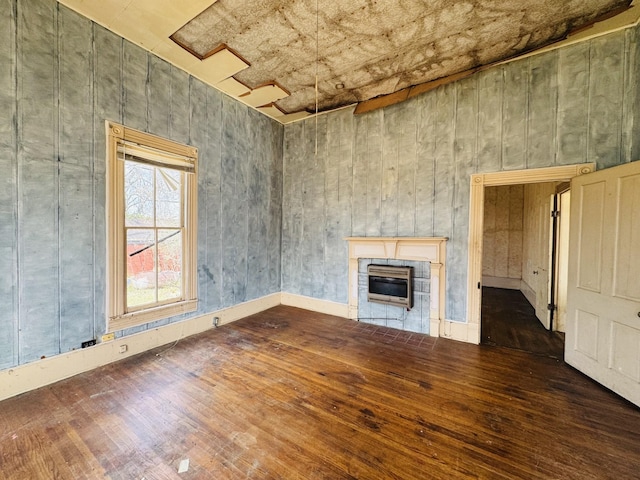 unfurnished living room featuring a glass covered fireplace and wood-type flooring