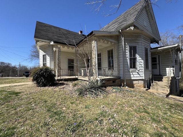 view of property exterior featuring crawl space, a yard, covered porch, and a shingled roof