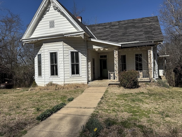 view of front of property featuring covered porch and a front yard