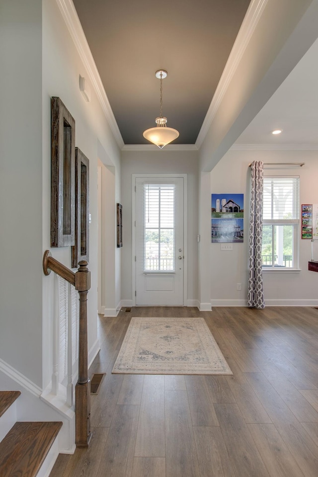 foyer entrance featuring visible vents, a healthy amount of sunlight, and wood finished floors