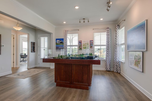 unfurnished office featuring rail lighting, baseboards, dark wood-style flooring, and crown molding