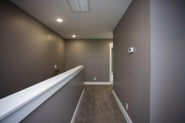 hallway featuring visible vents, an upstairs landing, recessed lighting, dark colored carpet, and baseboards