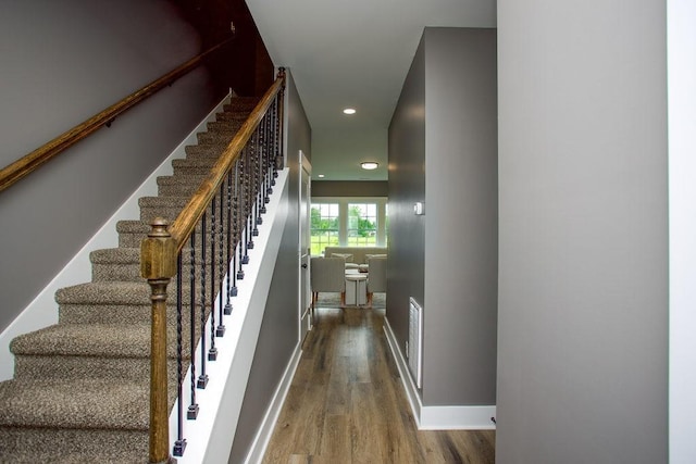 staircase with recessed lighting, visible vents, baseboards, and wood finished floors