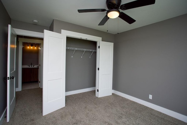 unfurnished bedroom with a sink, a closet, baseboards, and carpet floors