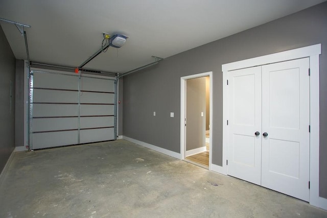 garage featuring a garage door opener and baseboards