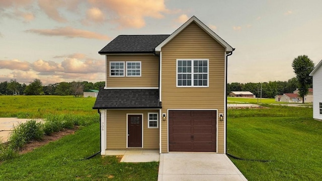 view of front of property with concrete driveway, an attached garage, a front yard, and a shingled roof