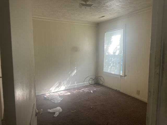 unfurnished room with visible vents, carpet, and a textured ceiling