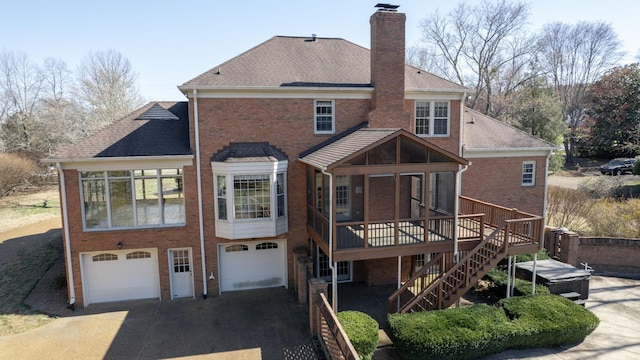 back of house with stairway, brick siding, driveway, and a chimney