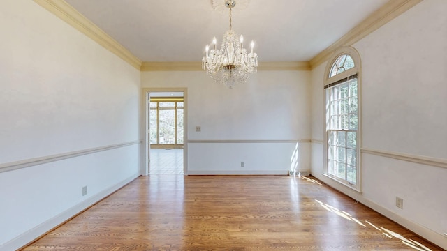 empty room featuring plenty of natural light, crown molding, and wood finished floors