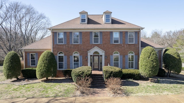 colonial inspired home featuring brick siding