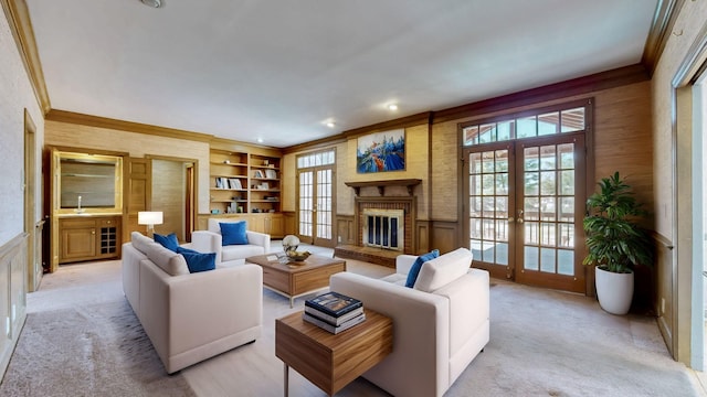 living room with a wainscoted wall, french doors, and crown molding