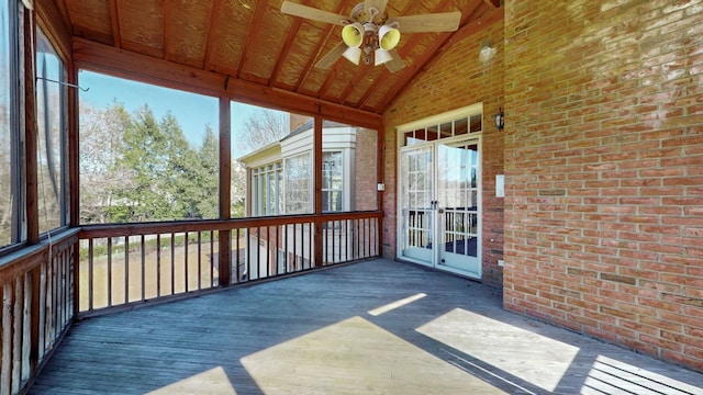 unfurnished sunroom featuring a ceiling fan and vaulted ceiling