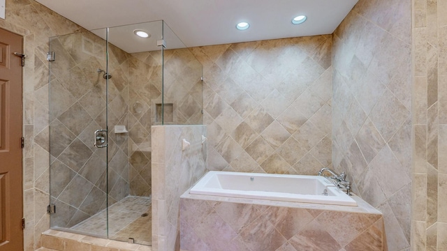 full bath with recessed lighting, a shower stall, and a garden tub