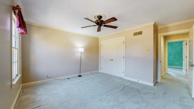 unfurnished bedroom with crown molding, light colored carpet, visible vents, and baseboards