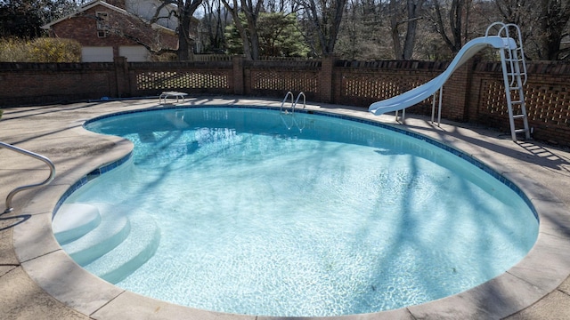 view of pool with a fenced in pool, a water slide, and a fenced backyard