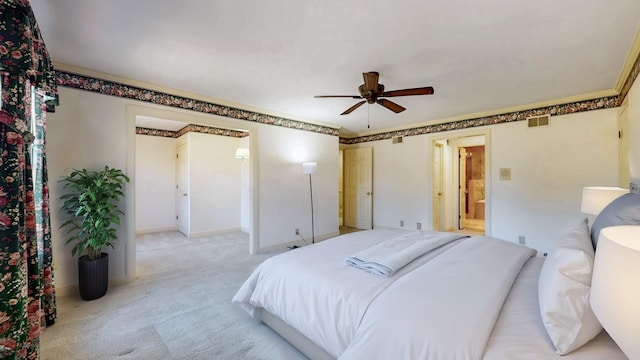 bedroom with visible vents, crown molding, baseboards, light carpet, and ensuite bathroom