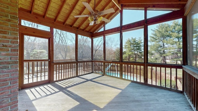 unfurnished sunroom featuring a ceiling fan, lofted ceiling with beams, and wood ceiling