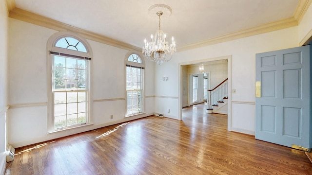 interior space featuring crown molding, baseboards, stairs, an inviting chandelier, and wood finished floors