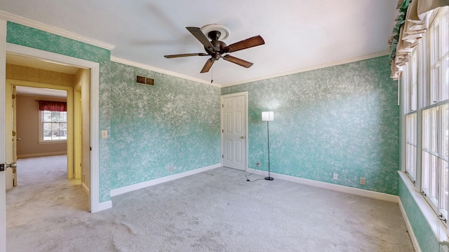 spare room with baseboards, carpet, ornamental molding, and wallpapered walls