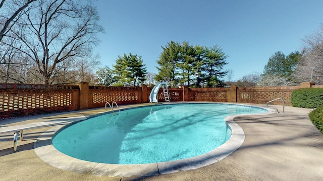 view of pool featuring a fenced in pool, a water slide, and fence