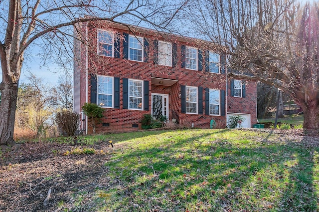 colonial home with crawl space, a front lawn, brick siding, and an attached garage