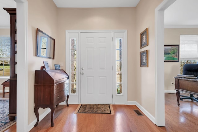 foyer entrance featuring wood finished floors, visible vents, and baseboards