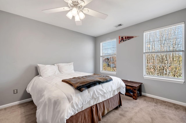 bedroom featuring visible vents, light colored carpet, and baseboards