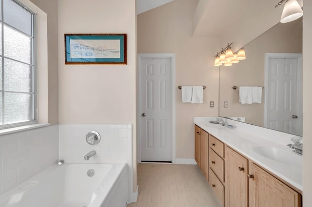 bathroom featuring a sink, a bath, double vanity, and tile patterned flooring