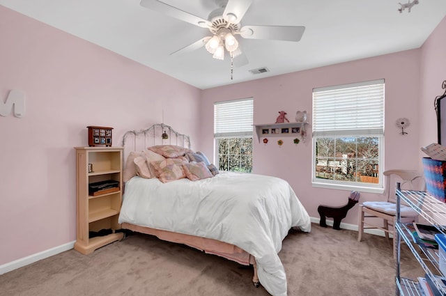 carpeted bedroom featuring visible vents, a ceiling fan, and baseboards