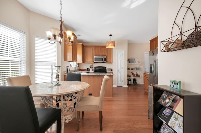 dining space featuring an inviting chandelier and wood finished floors