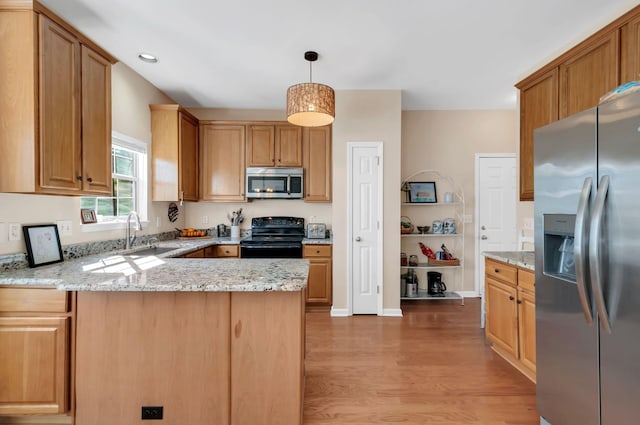 kitchen with light stone countertops, a peninsula, a sink, stainless steel appliances, and light wood-type flooring