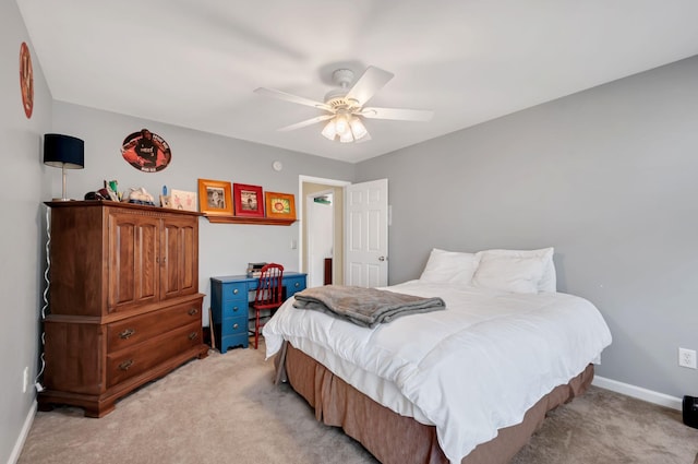 bedroom featuring baseboards, light colored carpet, and a ceiling fan