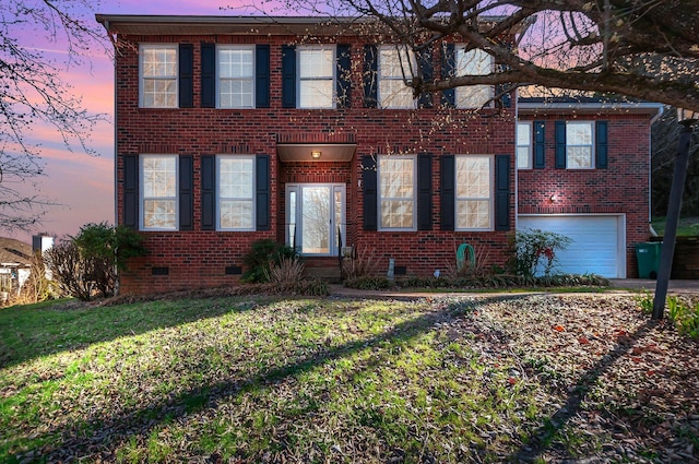 view of front facade featuring crawl space, a yard, an attached garage, and brick siding