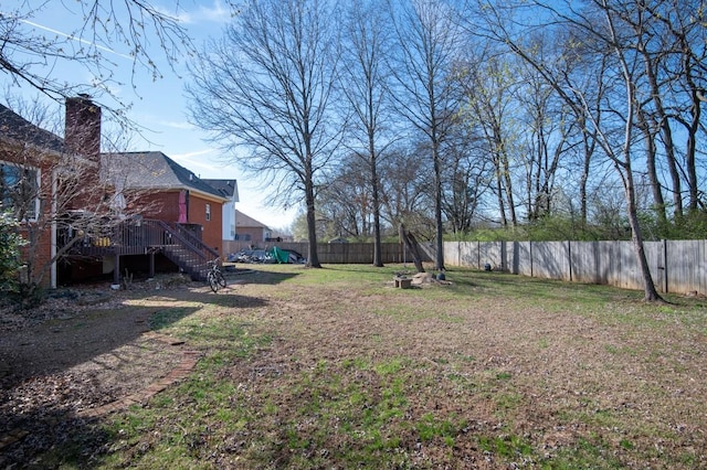 view of yard with a fenced backyard, stairs, and a wooden deck