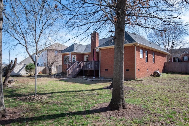 rear view of house featuring fence, stairs, crawl space, brick siding, and a yard