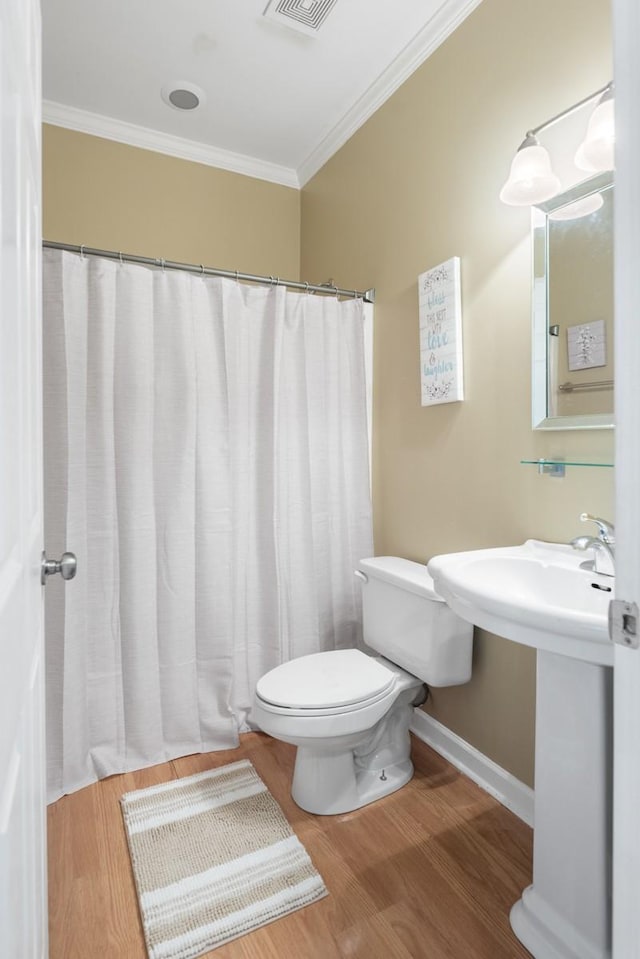 full bathroom with baseboards, wood finished floors, toilet, and crown molding