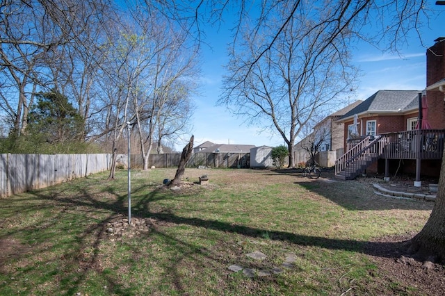 view of yard featuring stairs, a fenced backyard, and a deck