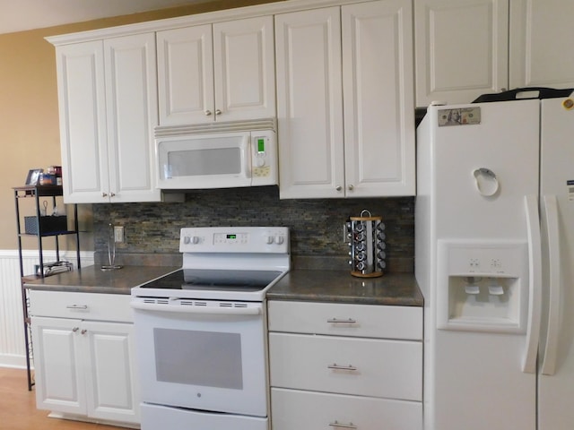 kitchen with white appliances, dark countertops, white cabinets, and tasteful backsplash