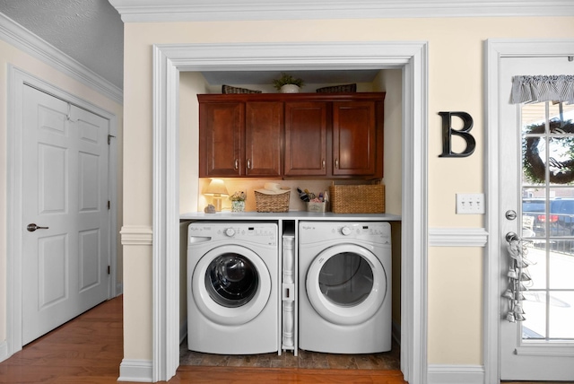 washroom featuring washer and clothes dryer, cabinet space, wood finished floors, and ornamental molding