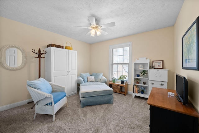 living area with a ceiling fan, baseboards, and carpet floors