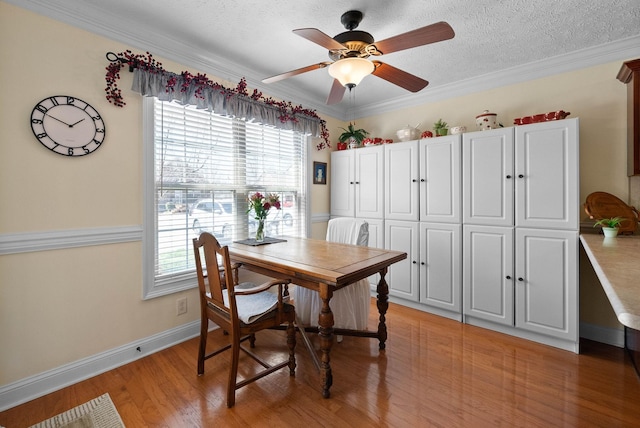 dining area featuring light wood finished floors, a healthy amount of sunlight, a textured ceiling, and baseboards