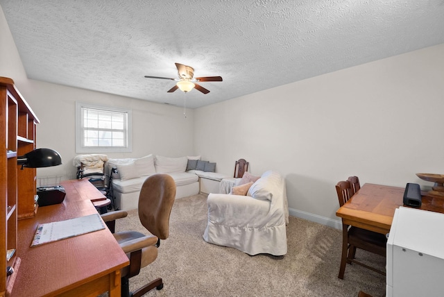 carpeted office featuring a ceiling fan, baseboards, and a textured ceiling