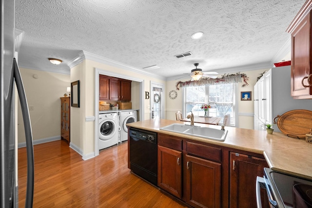 kitchen with washing machine and clothes dryer, freestanding refrigerator, a sink, light wood-style floors, and dishwasher