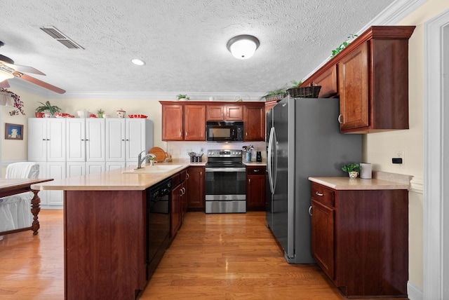 kitchen featuring a sink, visible vents, black appliances, and light countertops