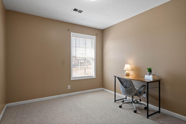 carpeted home office featuring visible vents, a textured ceiling, and baseboards