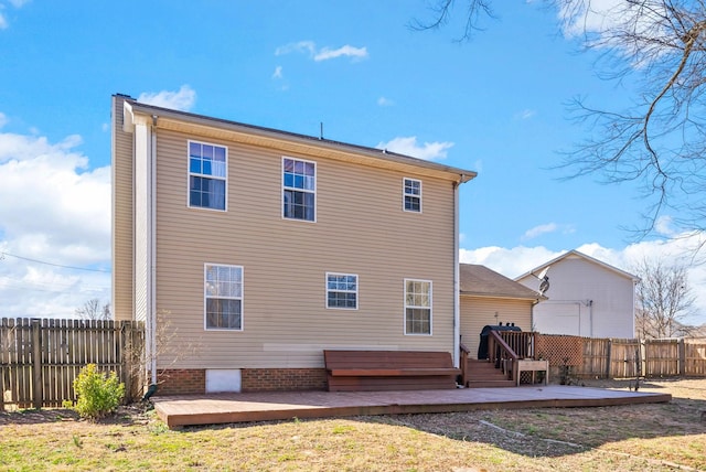 back of property with a wooden deck and a fenced backyard